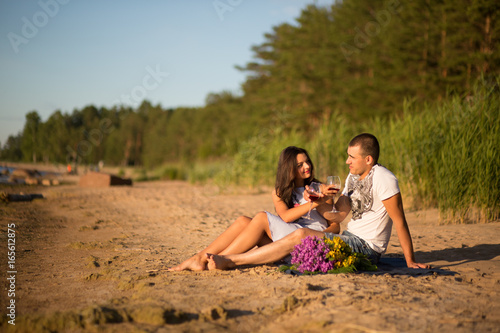 A young couple in love, on the shore of the Bay at sunset