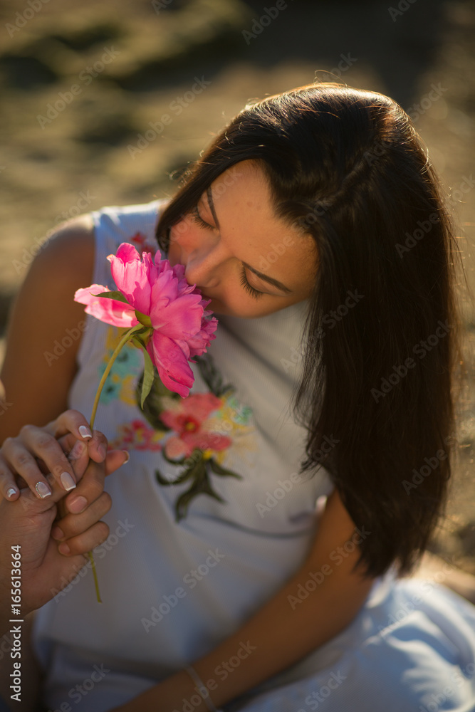 Fototapeta premium A young couple in love, on the shore of the Bay at sunset
