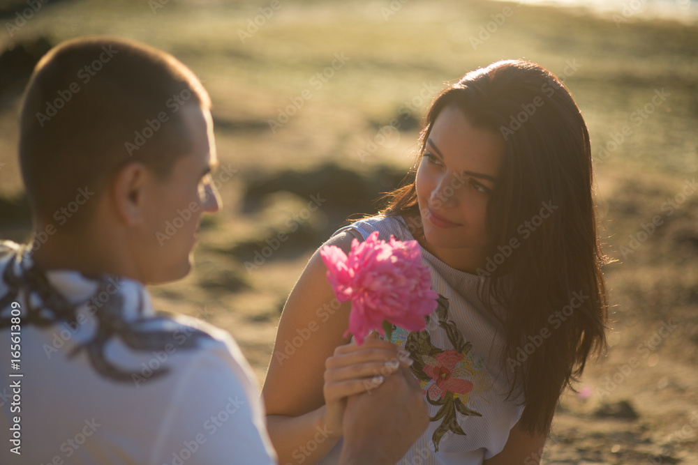 A young couple in love, on the shore of the Bay at sunset