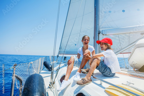 Brother and sister on board of sailing yacht on summer cruise. Travel adventure, yachting with child on family vacation. © Max Topchii