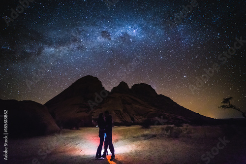 Landscape with Milky Way. Night sky with stars and silhouette of a couple.