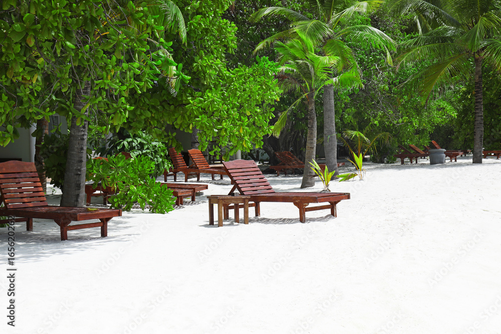 Obraz premium View of tropical beach with sun loungers on summer day
