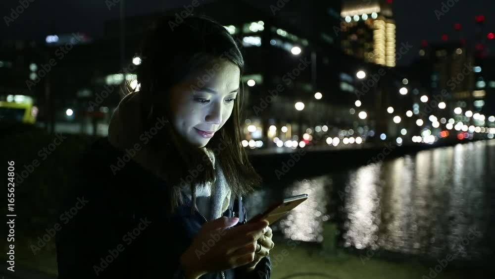 Woman using mobile phone at night Woman using mobile phone at night