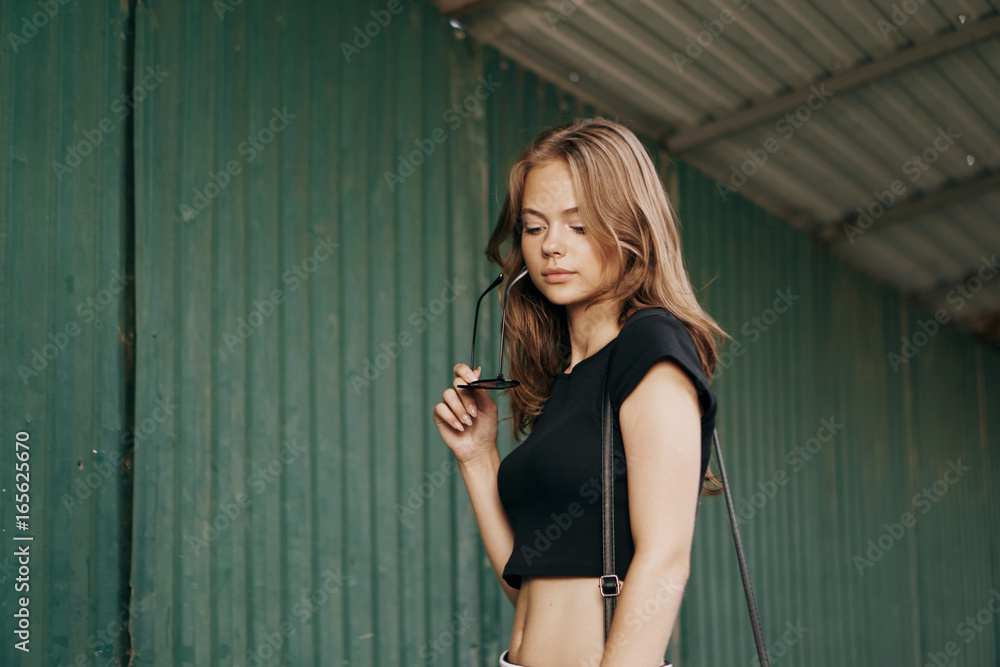Fototapeta premium Beautiful young woman walking outdoors in city in summer