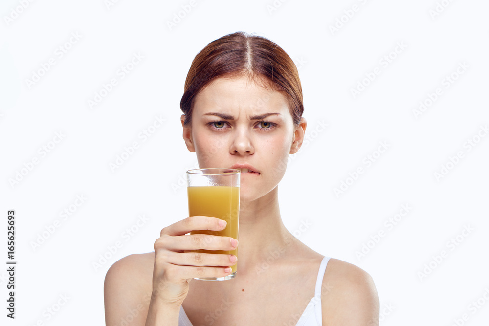 Beautiful young woman on a light background holds a glass of fresh juice, diet, proper nutrition Beautiful young woman on a light background holds a glass of fresh juice, diet, proper nutrition