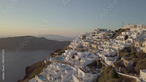 Santorini aerial view video of greek island with white houses and blue roofs on sunset and in the daylight on volcano and sea around the island, aero