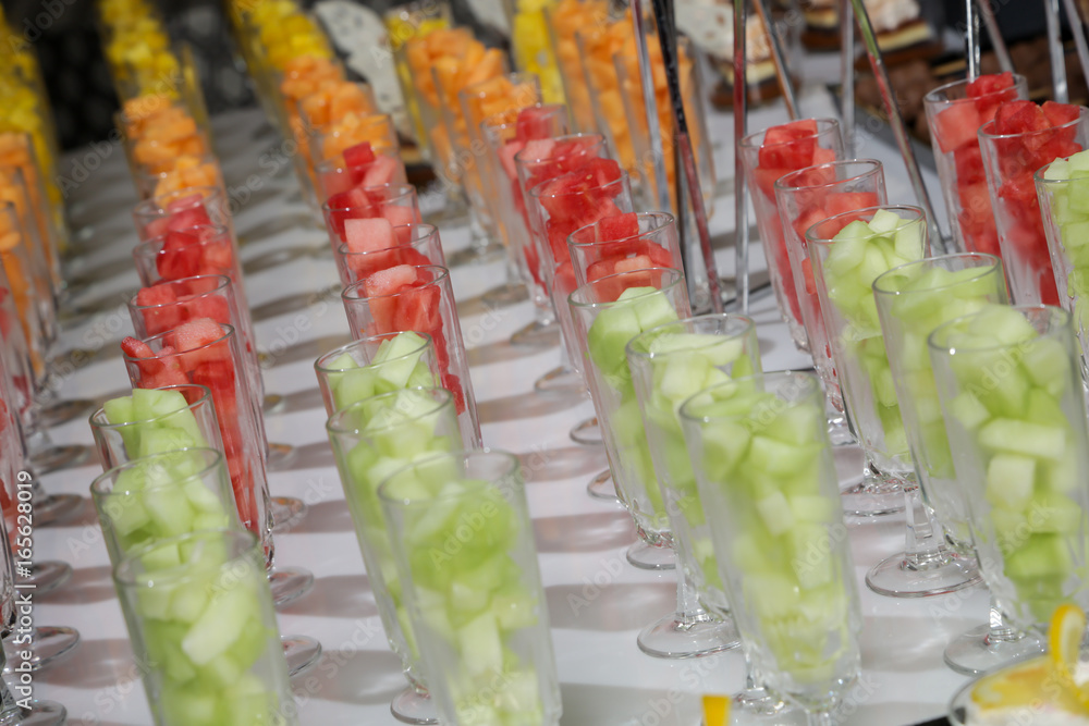 Sweet fresh mini glass flutes filled with fresh fruit salad melon watermelon pineapple event party wedding buffet catering Sweet fresh mini glass flutes filled with fresh fruit salad melon watermelon pineapple event party wedding buffet catering
