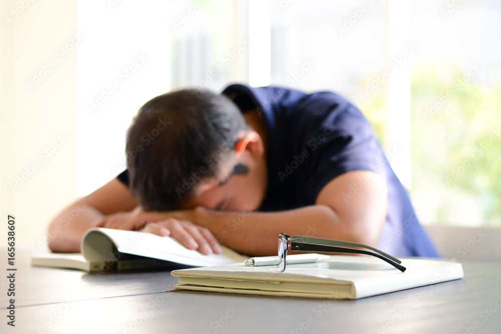 Young man sleeping on the table with book opened, weary & tired of reading  (studying) Stock Photo | Adobe Stock