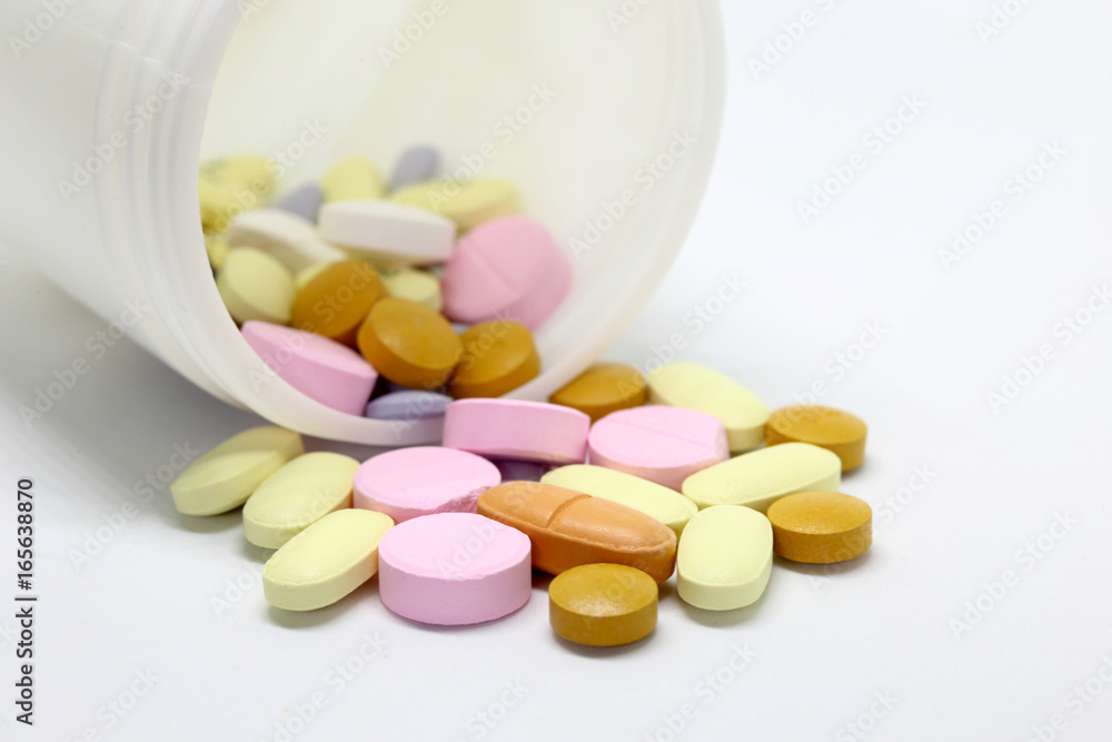 Medications in tablets and capsules on the white background Medications in tablets and capsules on the white background