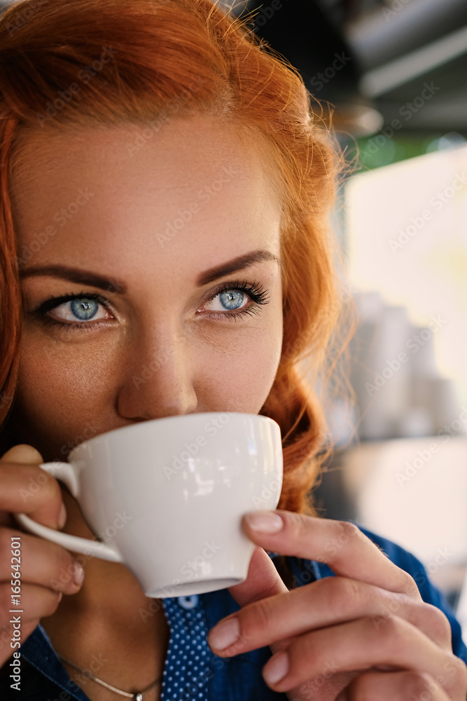 Portrait of redhead female barista drinks coffee. Portrait of redhead female barista drinks coffee.