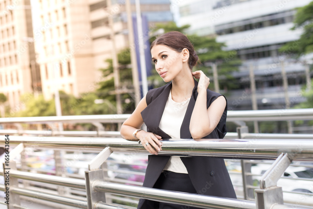 Fototapeta premium Young Beautiful business woman in city looking out and thinking about work. Young business woman with leader concept. White female thinking about business concept.