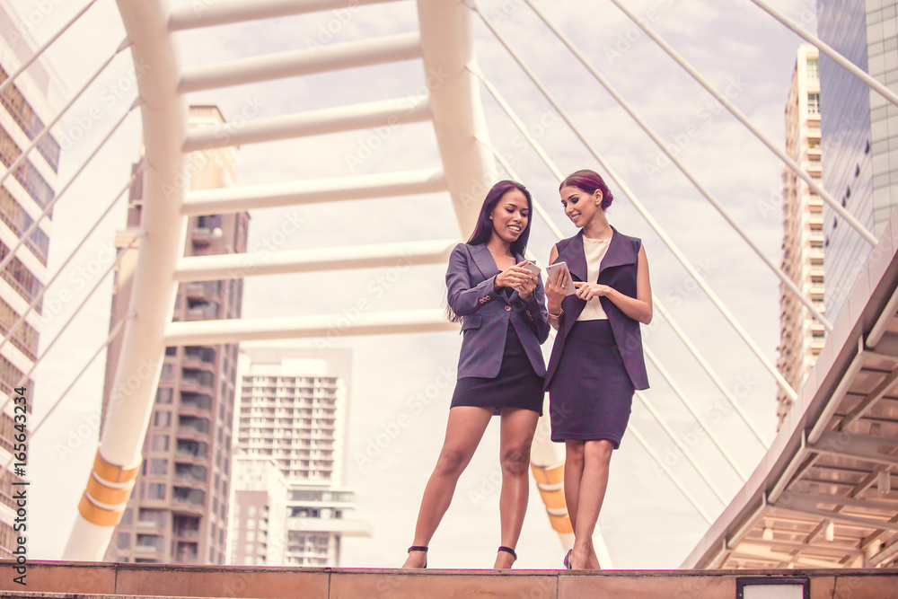 Young Beautiful business woman in city using smartphone for work. Young business woman with leader concept. Women thinking about business concept together. Young Beautiful business woman in city using smartphone for work. Young business woman with leader concept. Women thinking about business concept together.