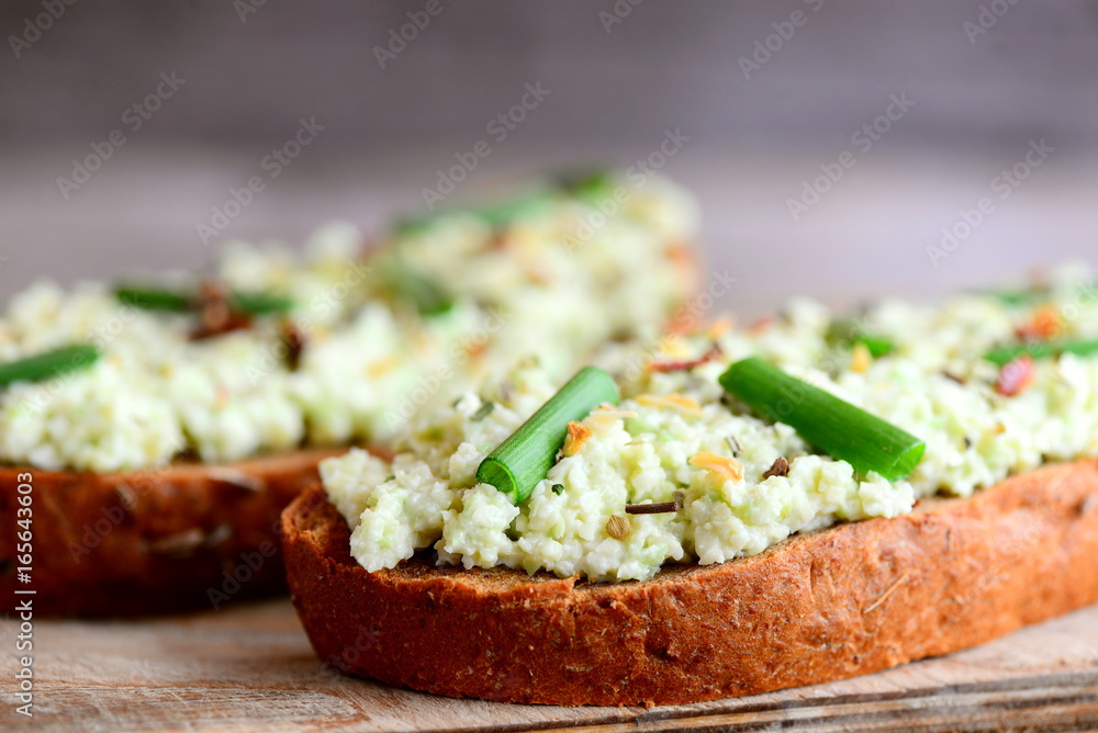 Simple open guacamole sandwiches with spices mix and fresh green onions. Avocado guacomole sandwiches recipe. Closeup Simple open guacamole sandwiches with spices mix and fresh green onions. Avocado guacomole sandwiches recipe. Closeup