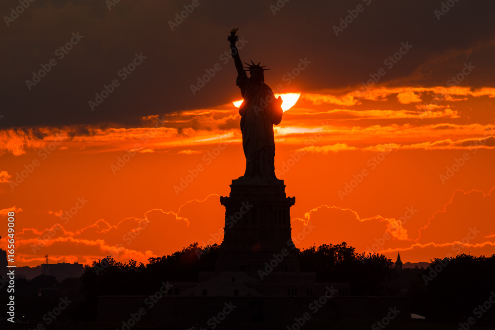 絶景 New York の日没 New York のシンボル自由の女神の後ろに夕日が沈みます 雲間からの夕日と女神像が重なり シルエットとなって 浮き上がります Stock Photo Adobe Stock 絶景 New York の日没 New York のシンボル自由の女神の後ろに夕日が沈みます 雲間からの夕日と女神像が重なり シルエットとなって 浮き上がります Stock Photo Adobe Stock