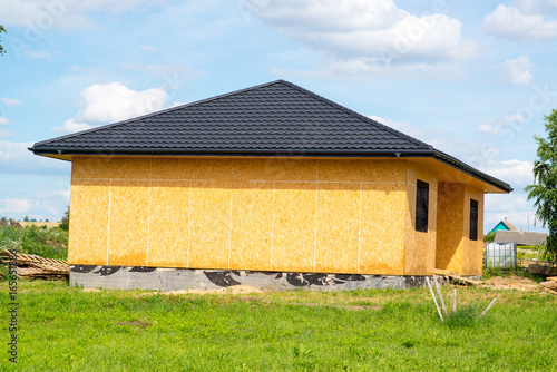 frame country house  lined with osb plates with brown roof made of metal