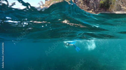 swimmer in flippers dives into the sea