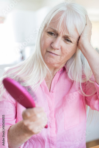 Senior Woman With Brush Corncerned About Hair Loss