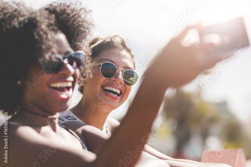 Young happy women taking themselves photo by mobile