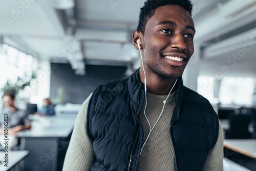 Happy african man listening music in office photo