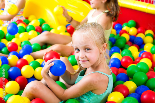 Girl playing with multicolored plastic balls