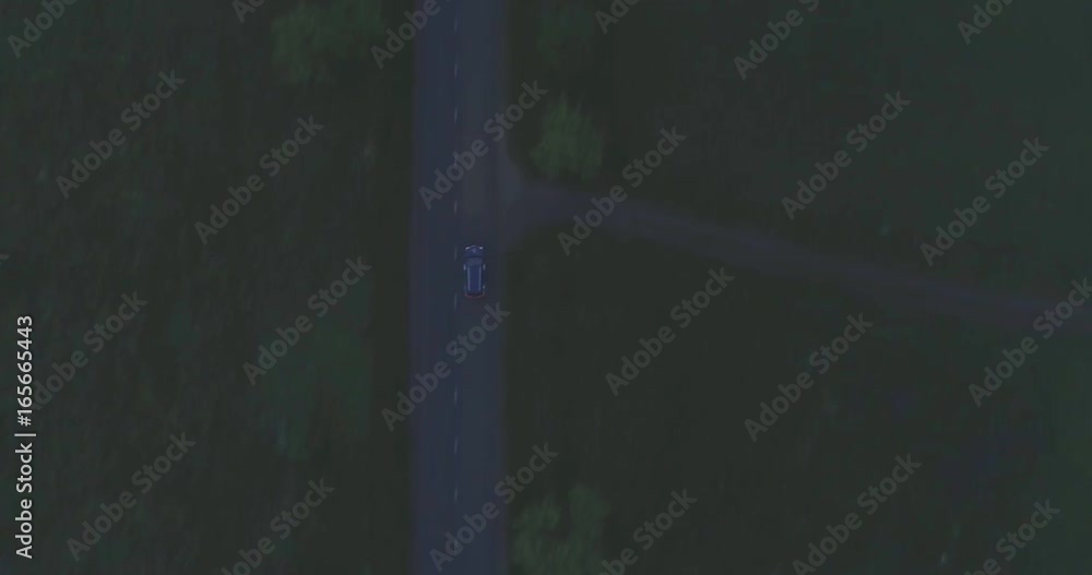 Camera follows black car, on the road at dusk. Aerial footage Camera follows black car, on the road at dusk. Aerial footage