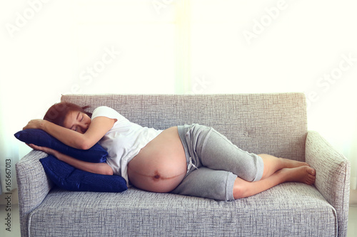woman pregnant sleeping on sofa furniture in living room