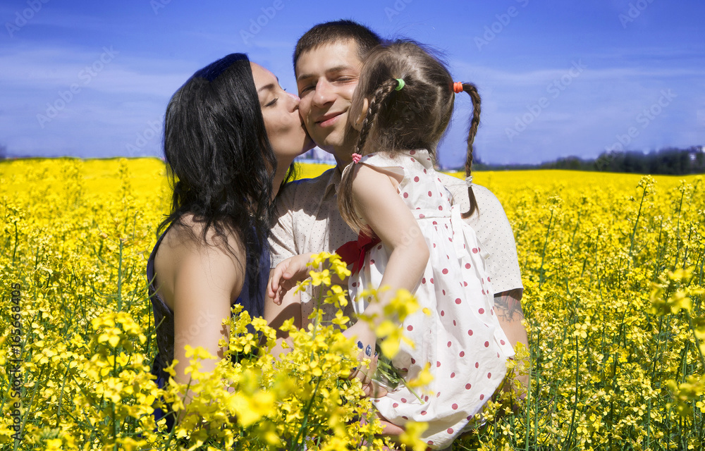 Happy family amongst yellow flowers in a field Happy family amongst yellow flowers in a field