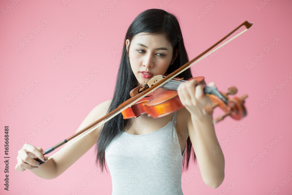 beautiful girl playing the violin on pink background beautiful girl playing the violin on pink background