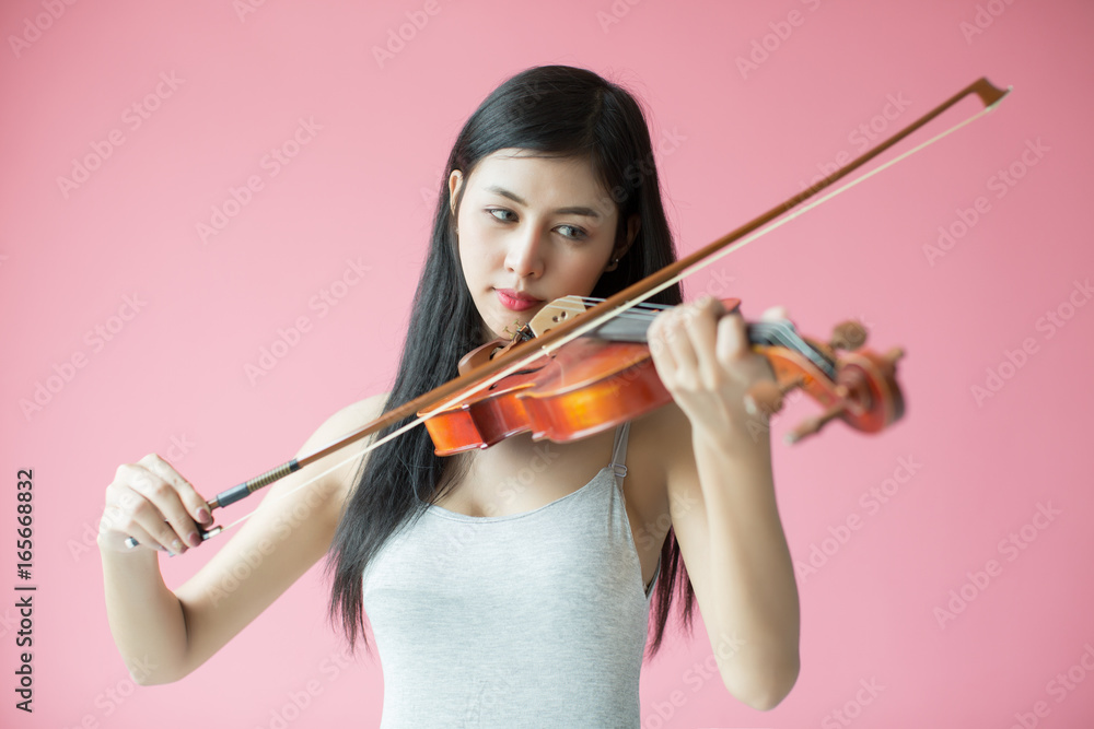 beautiful girl playing the violin on pink background beautiful girl playing the violin on pink background