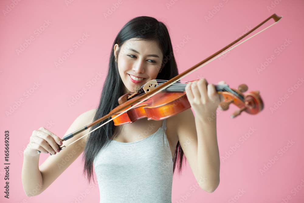 beautiful girl playing the violin on pink background beautiful girl playing the violin on pink background