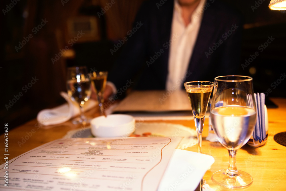 A glass of water and alcohol on the table in the restaurant. Meeting, dating