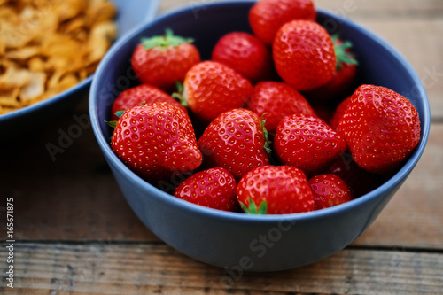 Delicious strawberry in a cup on a wooden desk.