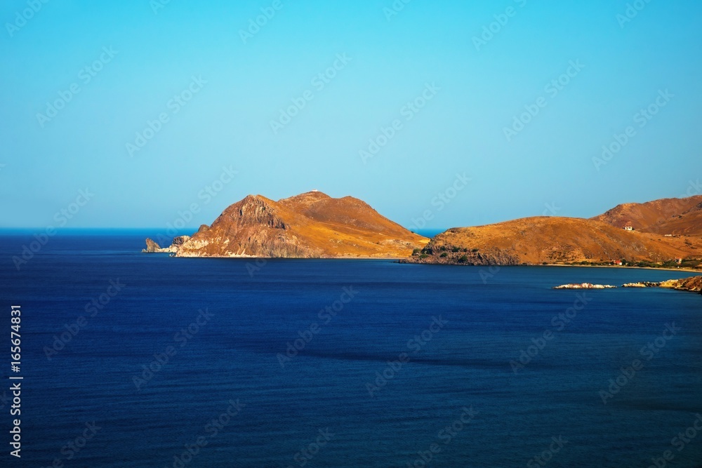 Coastline, hill and cliff in blue sea. Island Limnos, Greece.