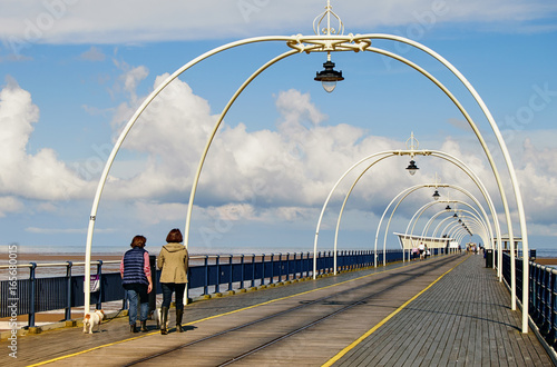 People walking along bridge, pier