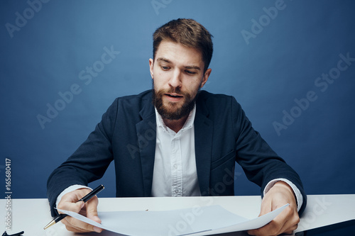 Business man working at desk in office on blue background