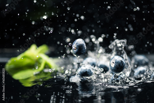 ripe blueberries dropping in water