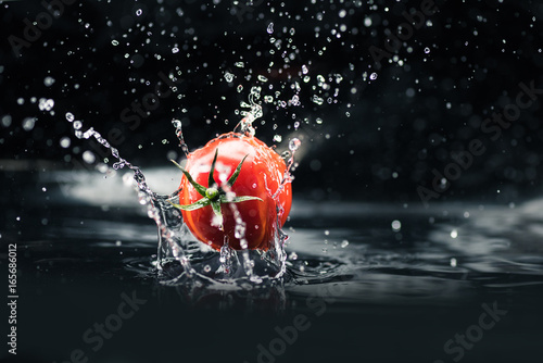 fresh tomato falling in water