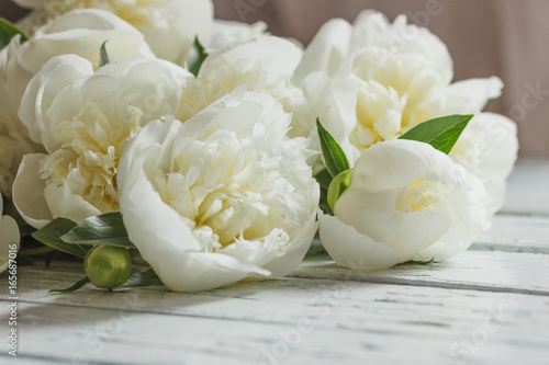 Bouquet of white peonies on the old white wooden boards