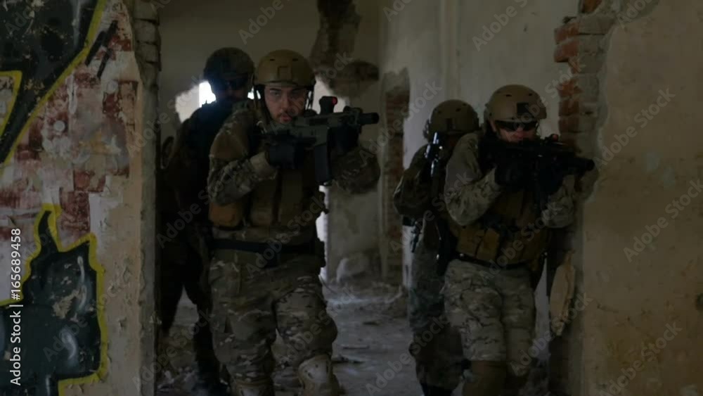 Group of soldiers moving fast through ruined building in search and rescue operation Group of soldiers moving fast through ruined building in search and rescue operation