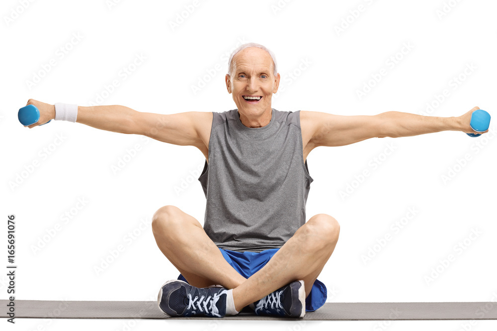 Elderly man lifting dumbbells and sitting on an exercise mat Elderly man lifting dumbbells and sitting on an exercise mat