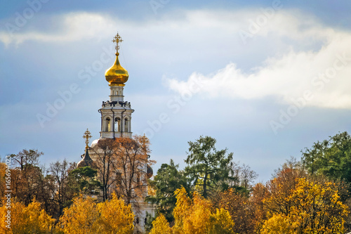 Orthodox church with golden dome on the background of the autumn forest