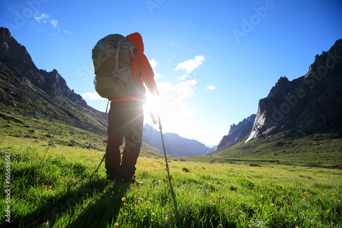 woman with backpack hiking in mountains travel lifestyle concept adventure active vacations outdoor mountaineering sport sunrise landscape