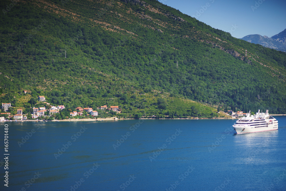 White passenger liner in the bay. Montenegro, Boka Kotorska bay on a hot summer day.