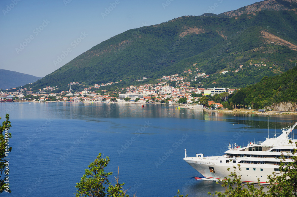 White passenger liner in the bay. Montenegro, Boka Kotorska bay on a hot summer day.