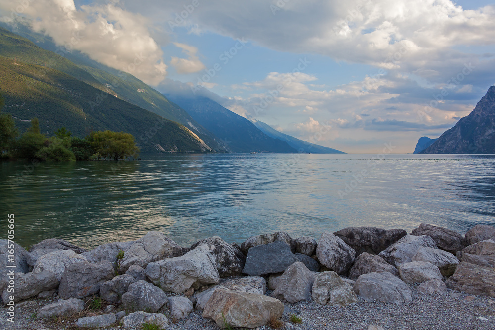 Picturesque view of the gorgeous mountain Garda Lake from Riva del Garda side by evening, Italy