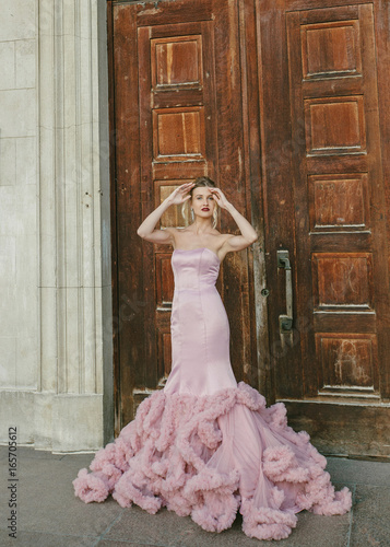 ridal Fashion. Portrait of young beautiful modern bride with stylish make-up and and hairdo in mermaid style wedding pink dress. photo