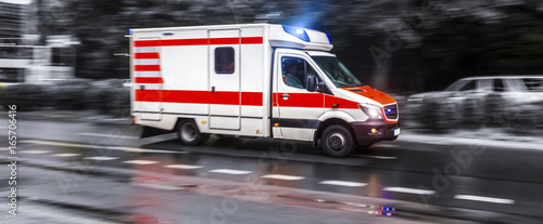 colored ambulance car speeding in black and white photo