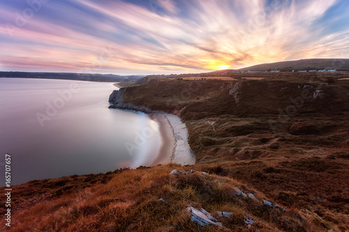Editorial Swansea, UK - July 24, 2017: Sunset over Tor Bay and Penmaen village on the Gower peninsula in Swansea, UK's first designated Area of Outstanding Natural Beauty, South Wales, UK