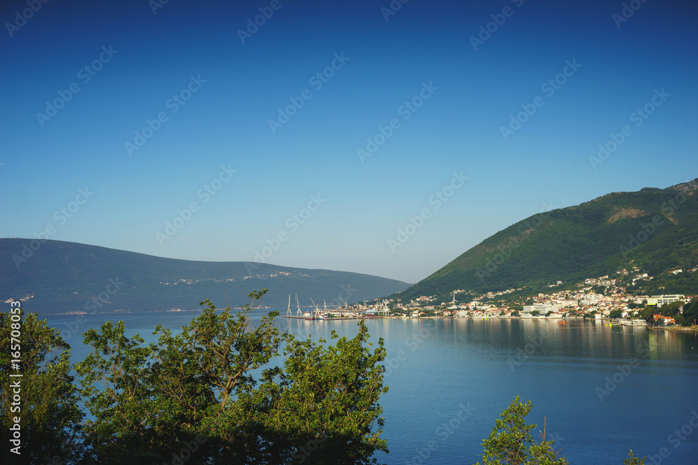 Fototapeta premium View of Boko Kotorska bay in Montenegro on a hot summer day. Vacation on the beach, the morning landscape in the bay.