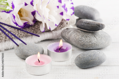 Spa composition with towels  lit candles  purple aroma sticks